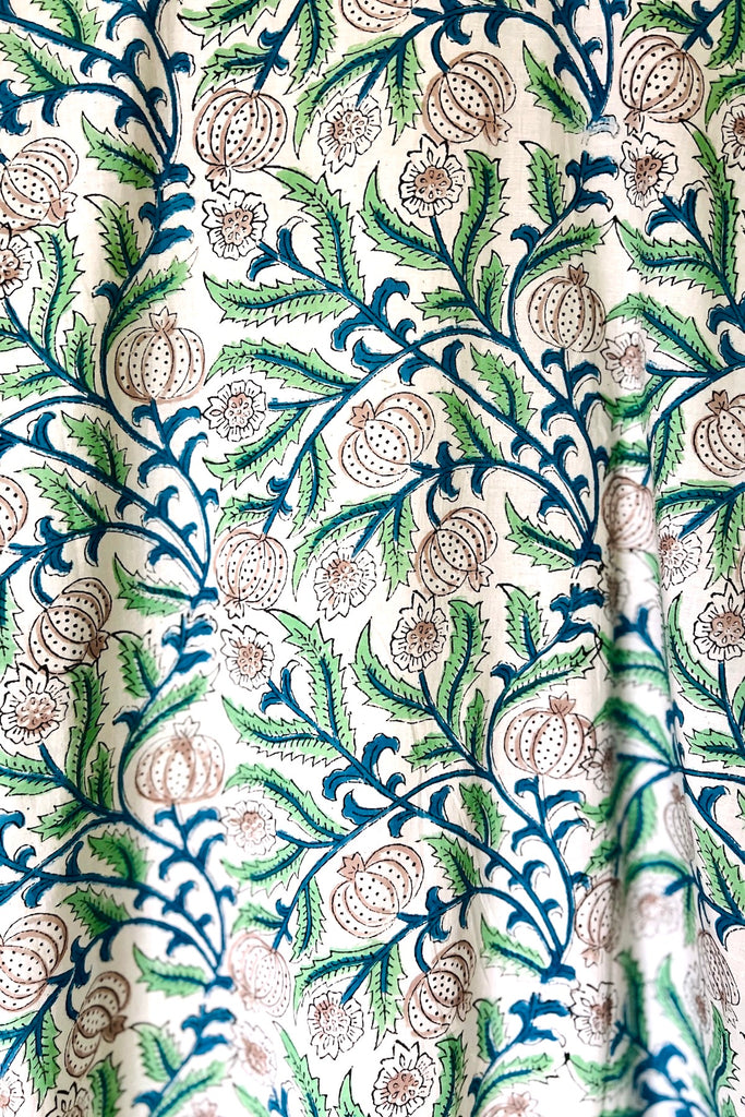 Close up of 'Arabella' print inspired by Arts and Crafts motifs of beige, light green and dark green seedheads and leaves on white ground