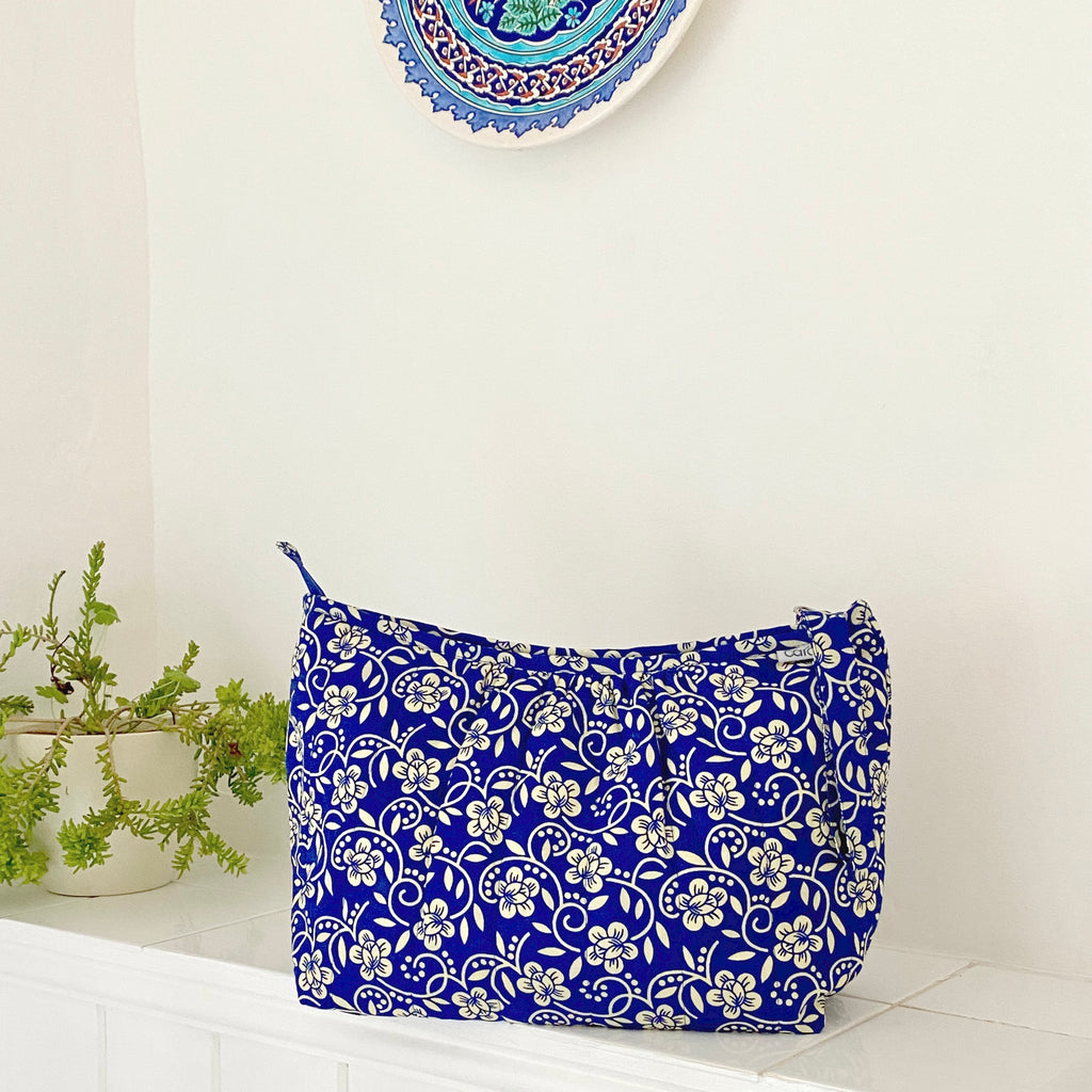 Blue and cream floral wash bag sitting on bathroom shelf