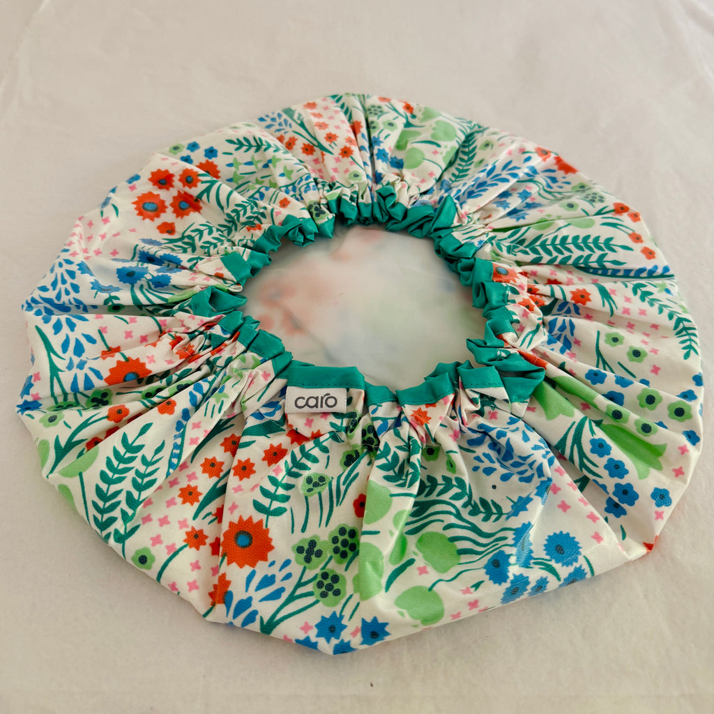 photo of Clara print turquoise, orange, green and white floral waterproof cotton print shower cap