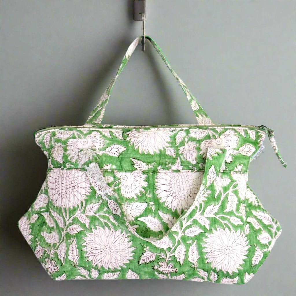 Green white sunflower print wash bag hanging from handle 