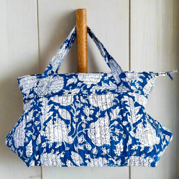 quilted wash bag with hanging handle in white floral on blue ground by caro london
