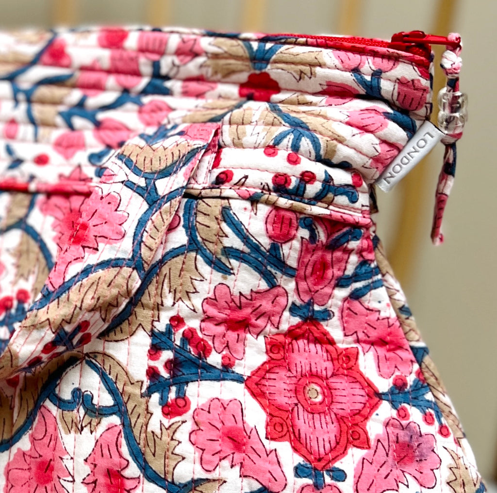 detail of pink and white floral print quilted washbag with carrying handles by Caro London