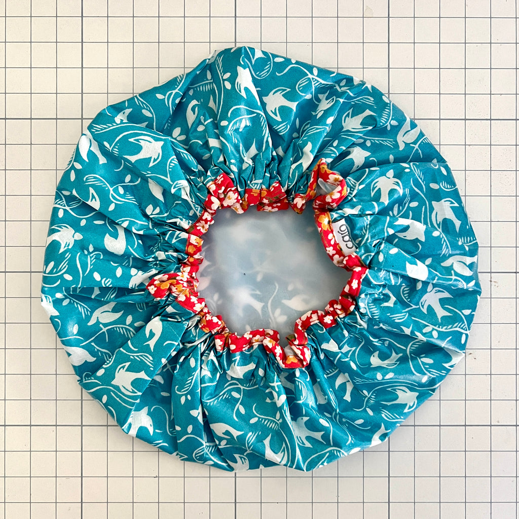 overhead shot of best selling teal swallow cotton print waterproofed shower cap and contrast print trim edge