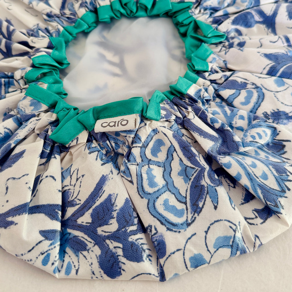 Close up of Caro's best selling blue and white Kirby print shower cap with turquoise trim