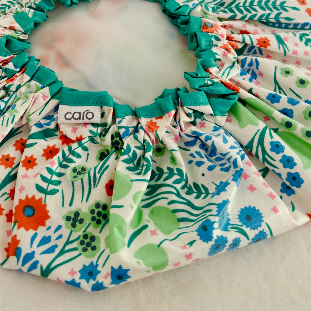 close up shot of turquoise, orange, green and white floral waterproof cotton print shower cap