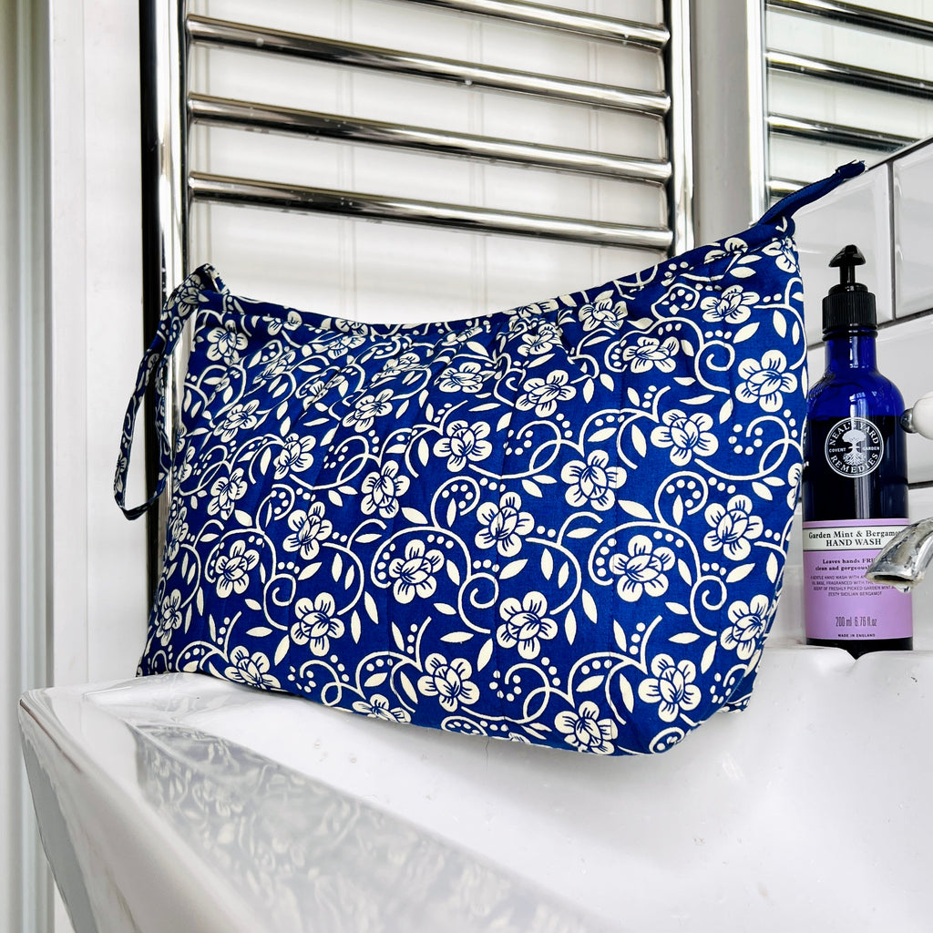 Close up of blue and cream floral wash bag sitting on wash basin