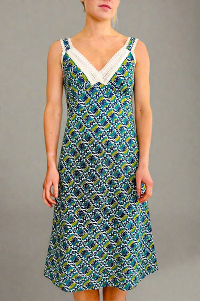 woman wearing printed floral strappy, fitted nightdress in blue, green and turquoise with white lace trim