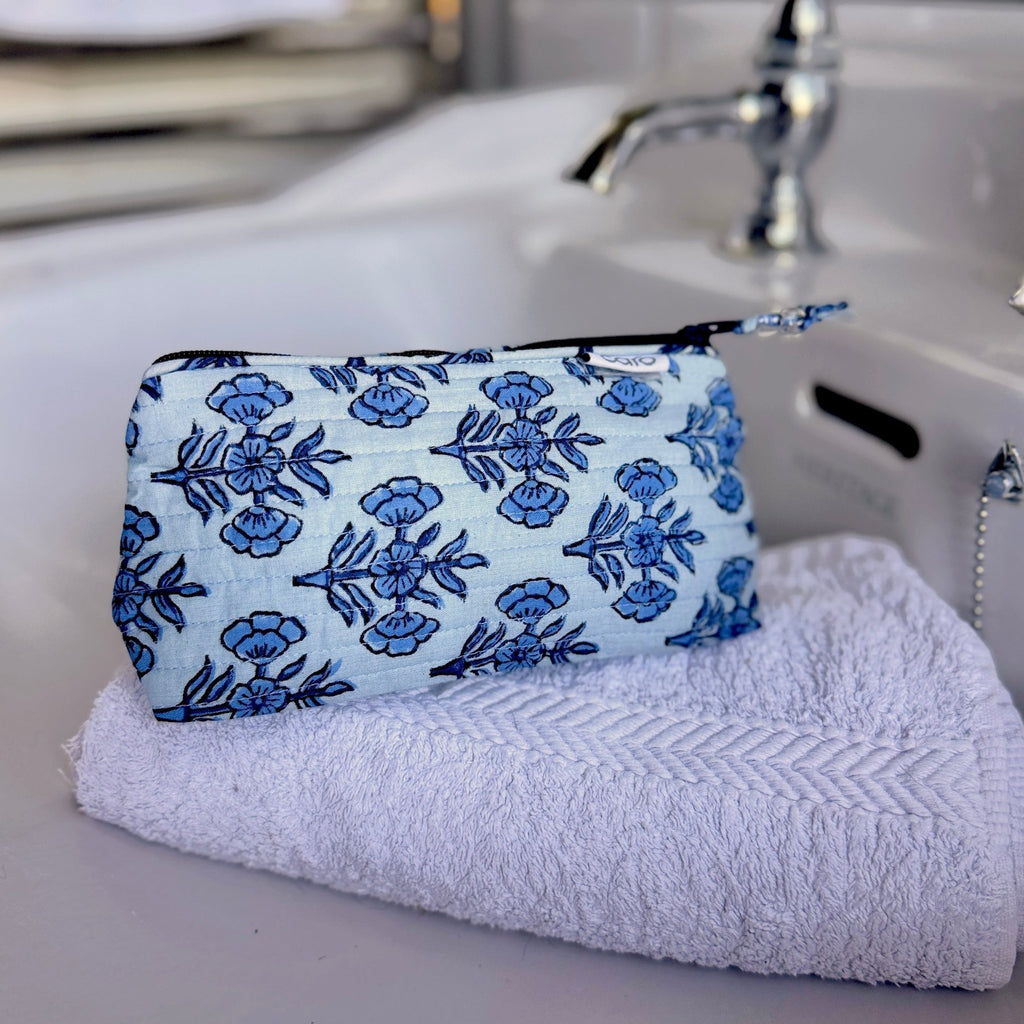 small make up bag made from blue single floral repeat motif on cotton with horizontal quilting