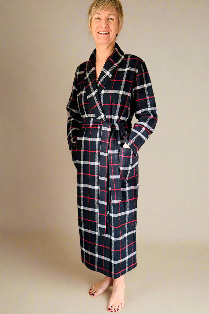 woman wearing black, white and red windowpane checked dressing gown with patch pockets and tie belt