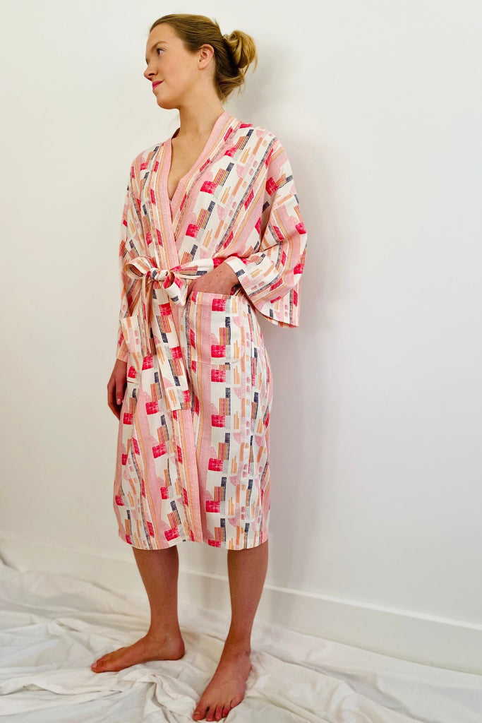 woman wearing knee length kimono in geometric print red,pink and white