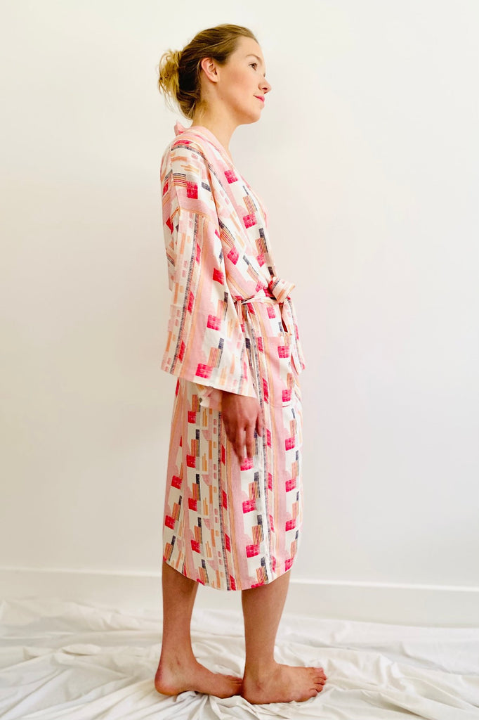 side view of woman wearing knee length kimono in geometric print red,pink and white