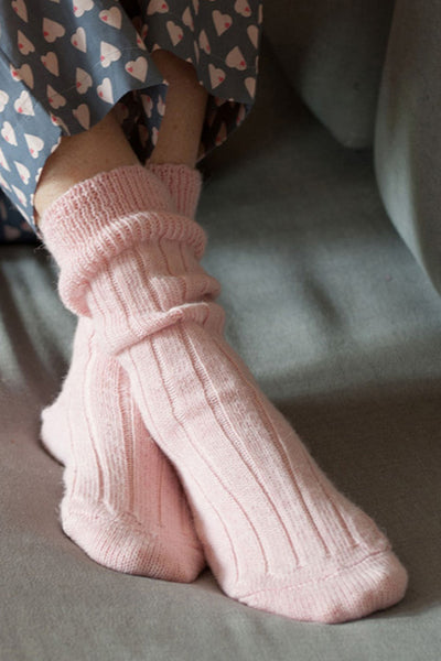 Close up shot of ladies pink bed socks worn with pyjama bottoms